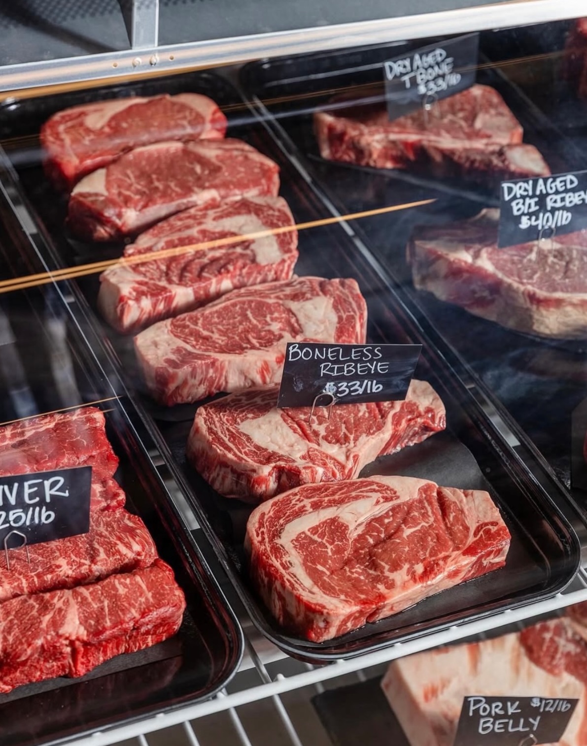 Butcher case with dry-aged ribeye and T-bone