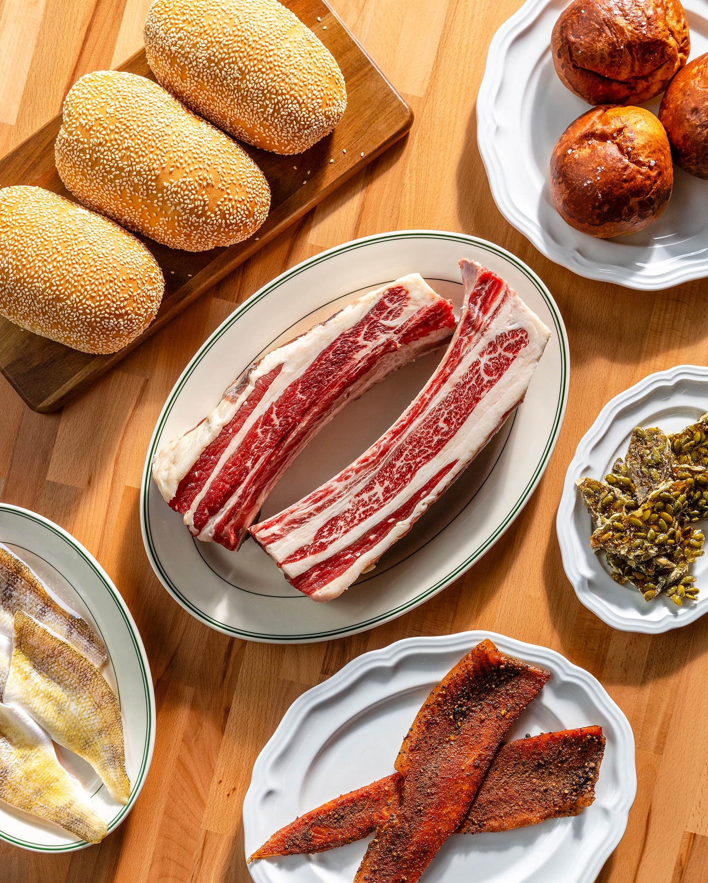 Butcher's spread with sesame rolls, ribs, and cured fish